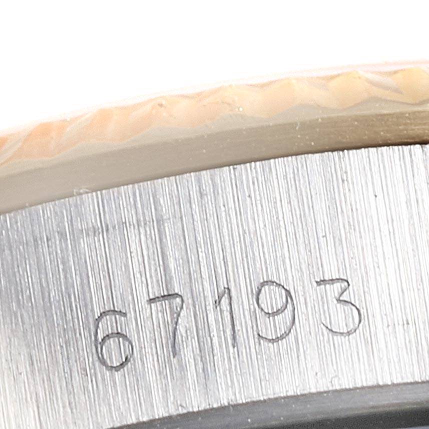 The image shows a close-up of the side of a Rolex Oyster Perpetual 67193 Women
s Steel and Gold (two tone) White Dial 67193 Women
s Steel and Gold (two tone) White Dial watch case, displaying its engraved serial number.