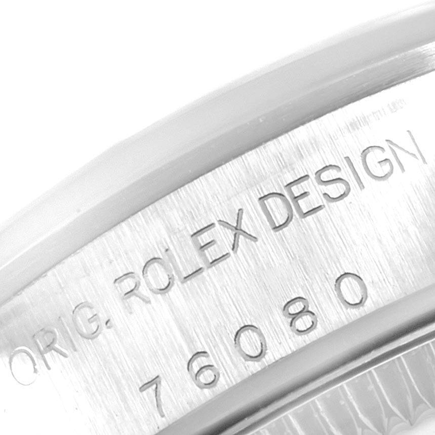 This image shows a close-up of the engraved serial number and 'Rolex Design' text on the case of a Rolex Oyster Perpetual 76080 Women's Stainless Steel Black Dial 76080 Women's Stainless Steel Black Dial watch.