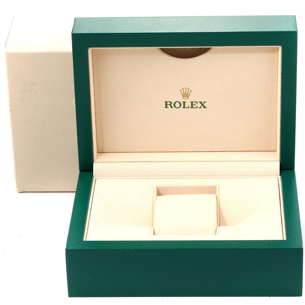 The image shows an open green and beige Rolex box for the Oyster Perpetual model.