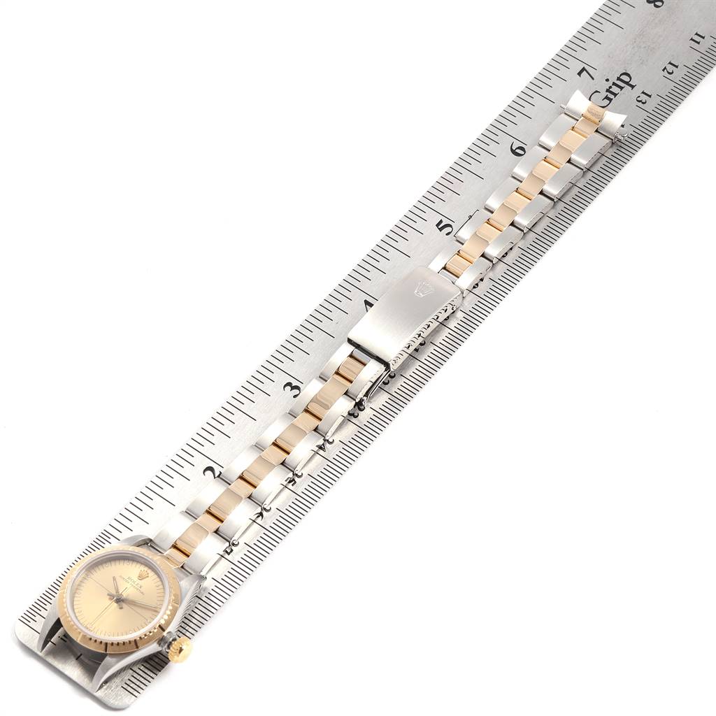 The Rolex Oyster Perpetual 67243 Women
s Steel and Gold (two tone) Champagne Dial 67243 Women
s Steel and Gold (two tone) Champagne Dial watch is shown from a top-down angle, highlighting the face, crown, and bracelet.