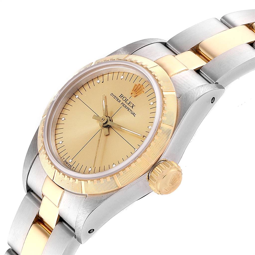 The image shows a close-up side angle of the Rolex Oyster Perpetual 67243 Women
s Steel and Gold (two tone) Champagne Dial 67243 Women
s Steel and Gold (two tone) Champagne Dial, highlighting its gold dial, bezel, crown, and two-tone bracelet.