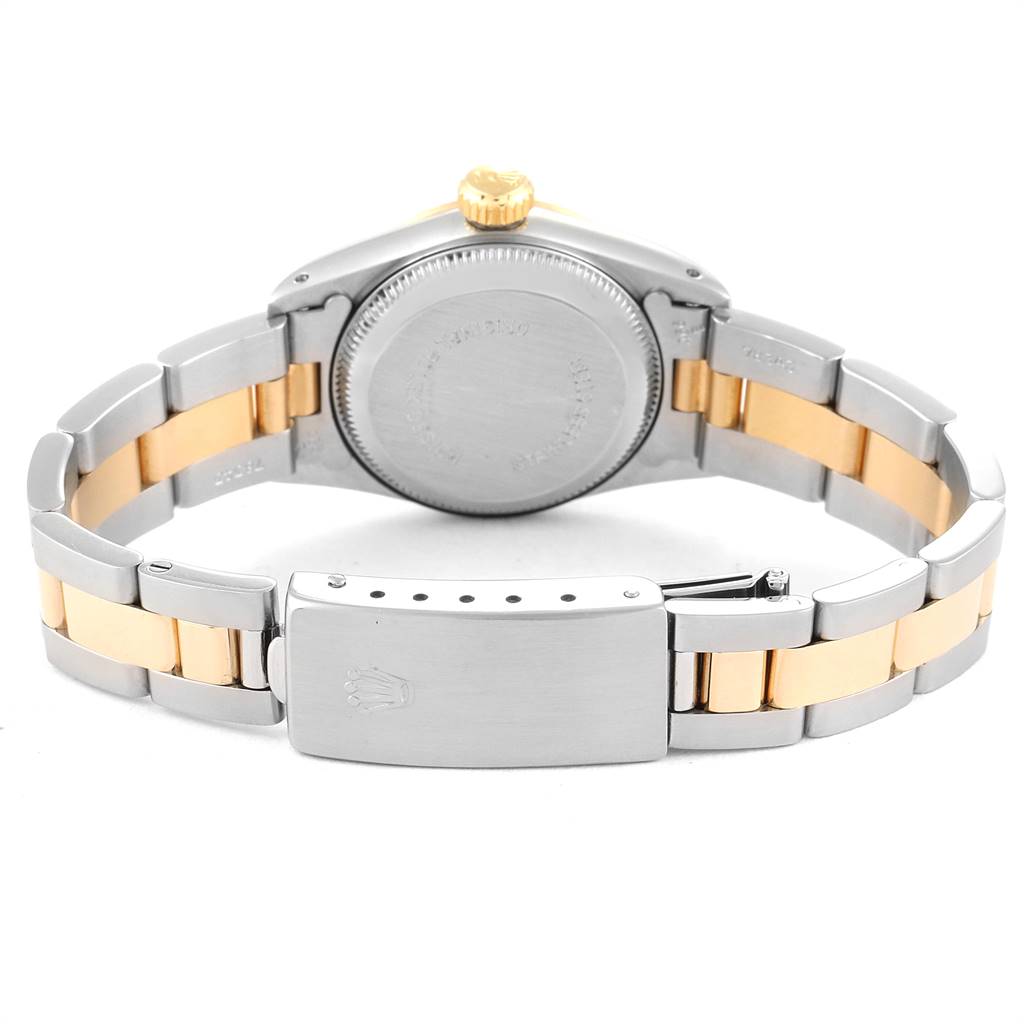 The image shows the back case and clasp of a Rolex Oyster Perpetual 67243 Women
s Steel and Gold (two tone) Champagne Dial 67243 Women
s Steel and Gold (two tone) Champagne Dial watch with a two-tone metal bracelet.