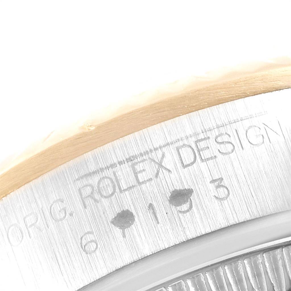 This close-up image shows the edge of the casing for a Rolex Oyster Perpetual 67193 Women
s Steel and Gold (two tone) Champagne Dial 67193 Women
s Steel and Gold (two tone) Champagne Dial watch, displaying engraved text and numerals.