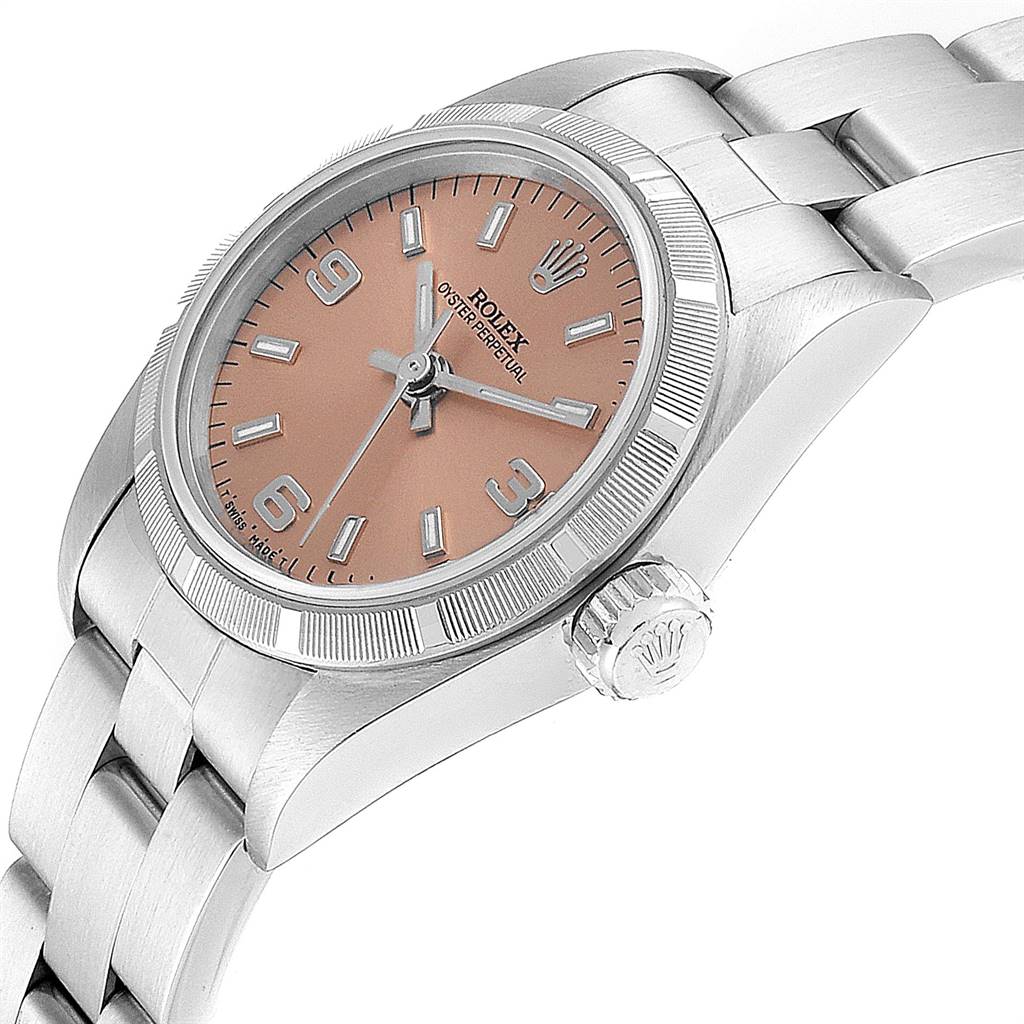 This image shows a side view of the Rolex Oyster Perpetual 67230 Women's Stainless Steel Pink Dial 67230 Women's Stainless Steel Pink Dial watch focusing on the crown, bezel, part of the dial, and bracelet.