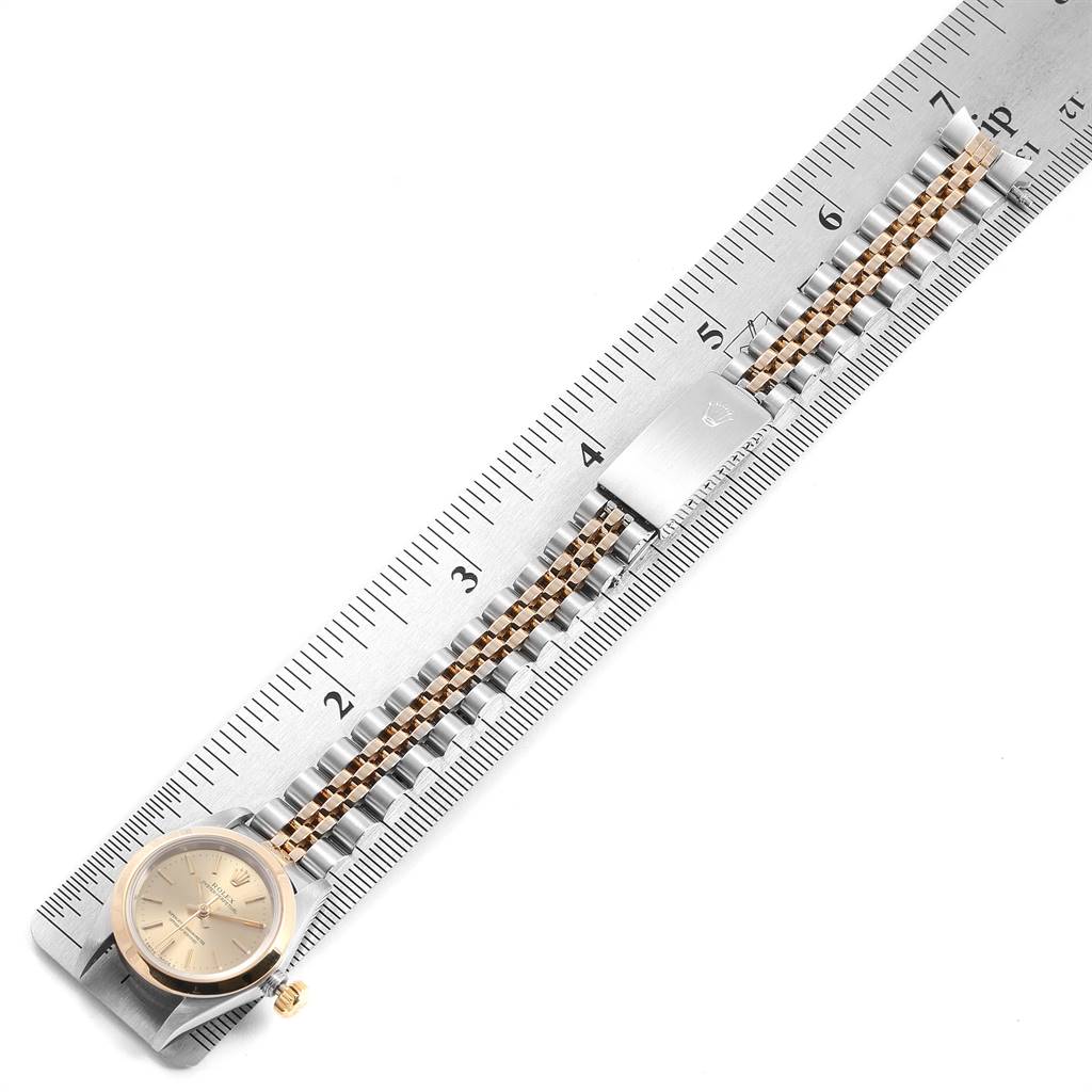 The Rolex Oyster Perpetual 67183 Women
s Steel and Gold (two tone) Champagne Dial 67183 Women
s Steel and Gold (two tone) Champagne Dial watch is shown flat and fully extended with its bracelet placed alongside a ruler for measurement.