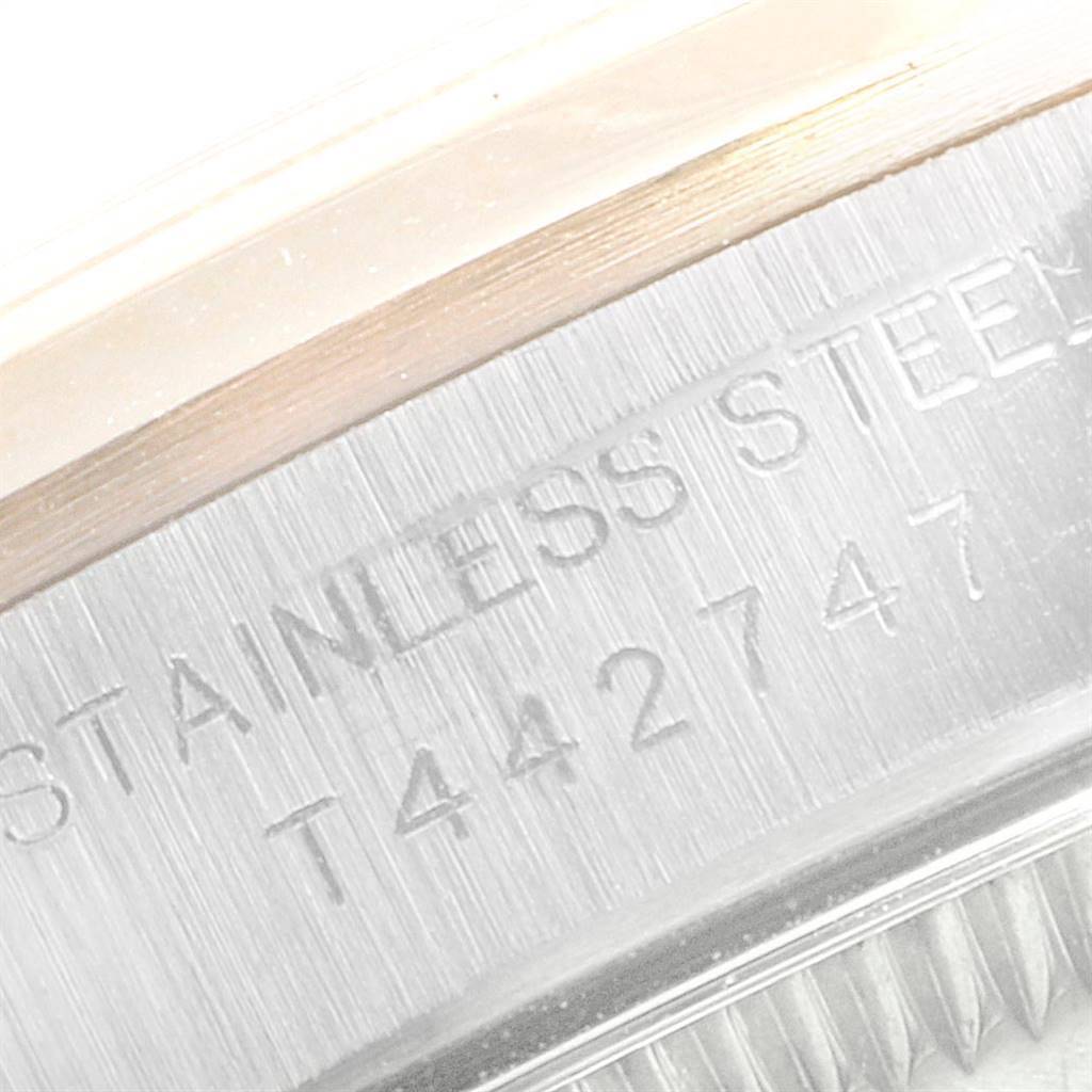 This close-up image shows the side engraving of a Rolex Oyster Perpetual 67183 Women
s Steel and Gold (two tone) Champagne Dial 67183 Women
s Steel and Gold (two tone) Champagne Dial watch case, highlighting the "STAINLESS STEEL" text and serial number.