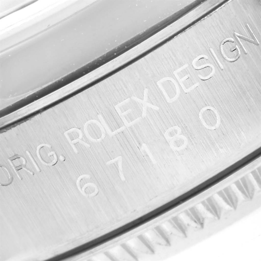 The image shows a close-up of the engraved case side of a Rolex Oyster Perpetual 67180 Women's Stainless Steel Silver Dial 67180 Women's Stainless Steel Silver Dial watch, displaying the model number and text "ROLEX DESIGN."