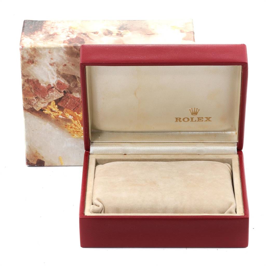 The image shows an open red Rolex box for the Oyster Perpetual model, featuring the branded interior and a cushion for the watch.