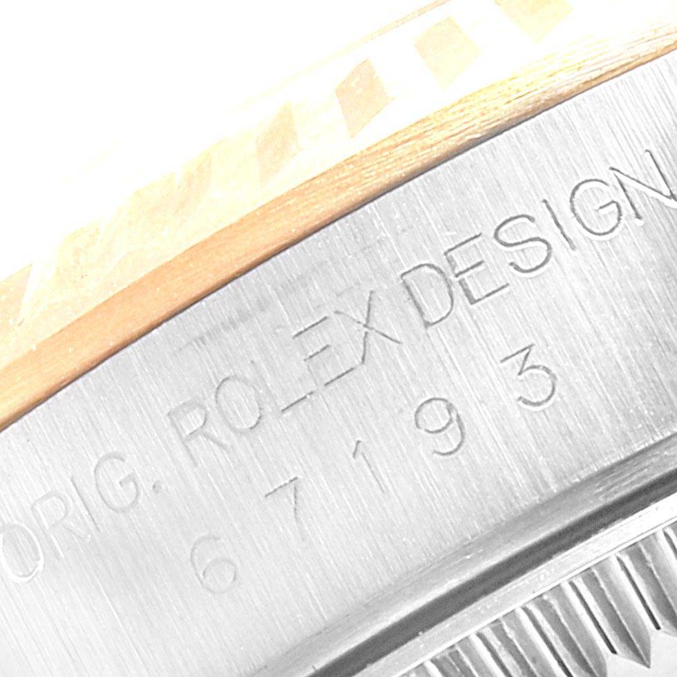 Close-up of the case side engraving on a Rolex Oyster Perpetual 67193 Women
s Steel and Gold (two tone) Champagne Dial 67193 Women
s Steel and Gold (two tone) Champagne Dial watch, showing the "Rolex Design" inscription and part number.