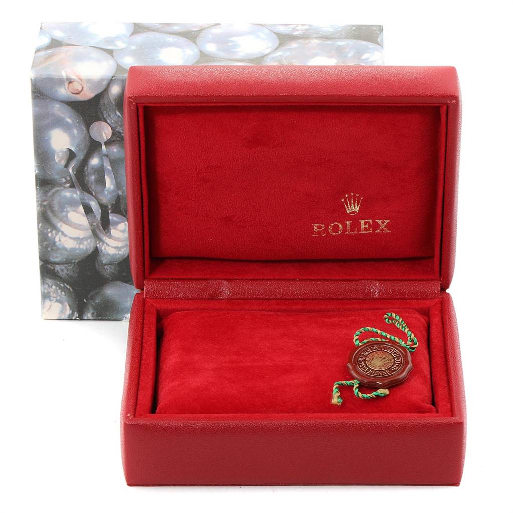 This image shows an empty red Rolex jewelry box with a green and red string accessory for the Oyster Perpetual model.