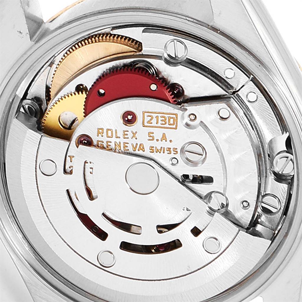 This is a close-up view of the movement mechanism of a Rolex Oyster Perpetual 67193 Women
s Steel and Gold (two tone) Champagne Dial 67193 Women
s Steel and Gold (two tone) Champagne Dial watch, showing gears, inscriptions, and intricate components.