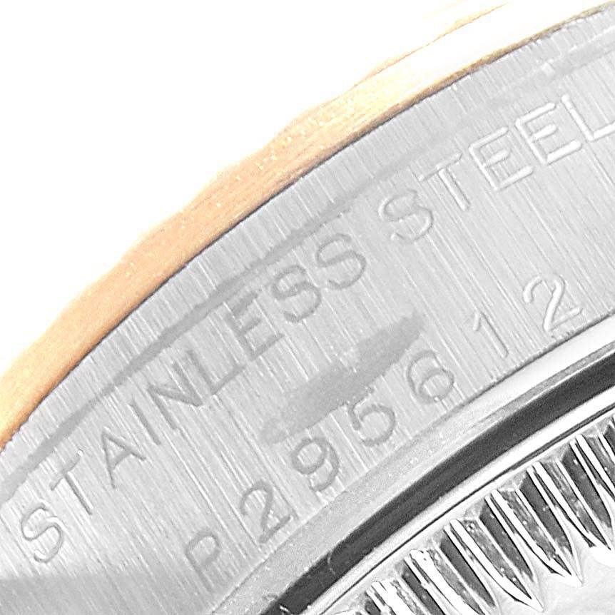 This is a close-up of the edge of a Rolex Oyster Perpetual 76193 Women
s Steel and Gold (two tone) Black Dial 76193 Women
s Steel and Gold (two tone) Black Dial model, showing part of the stainless steel casing with engraved markings.