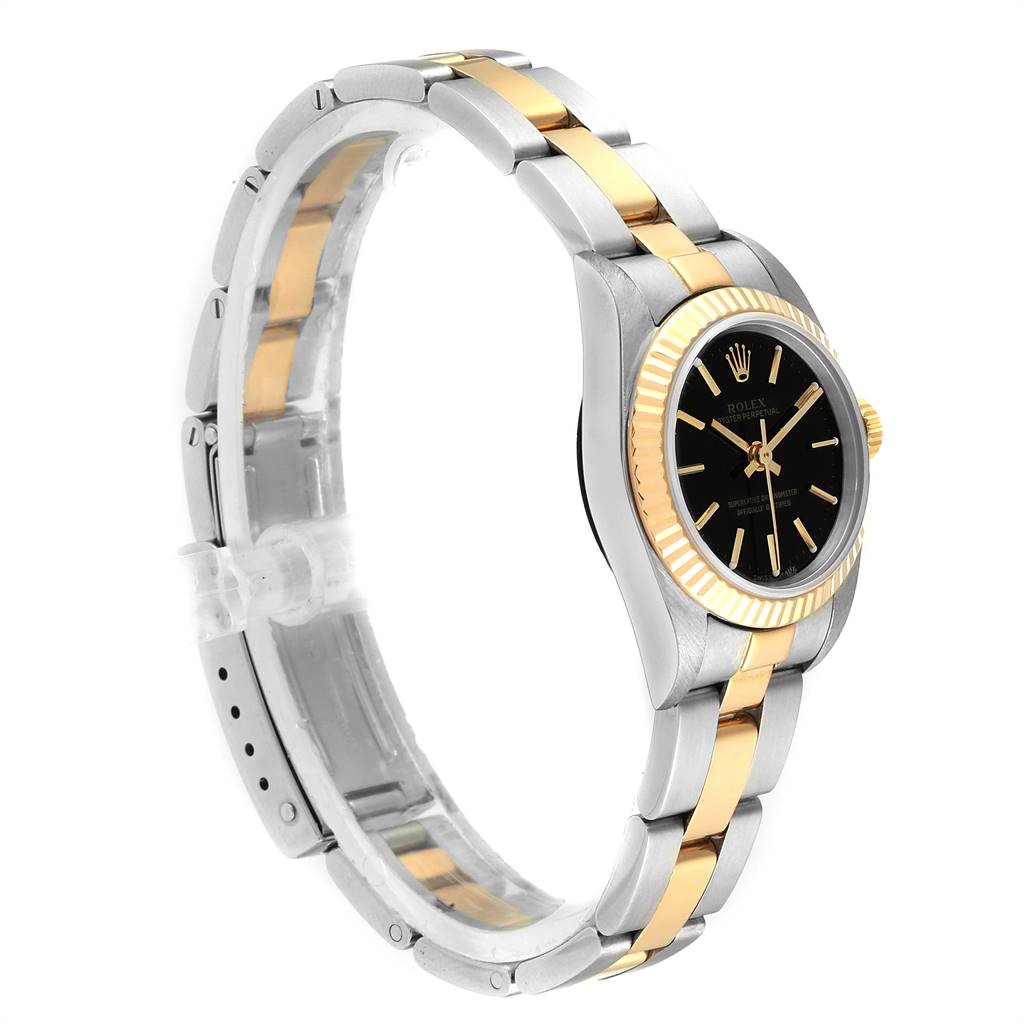 The Rolex Oyster Perpetual 76193 Women
s Steel and Gold (two tone) Black Dial 76193 Women
s Steel and Gold (two tone) Black Dial watch is shown at an angle, displaying its gold and silver bracelet and black dial.