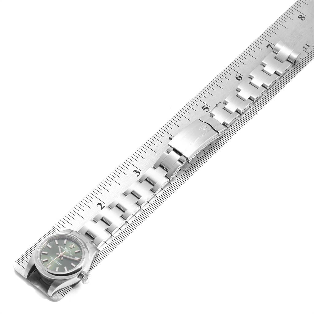 The image shows a Rolex Oyster Perpetual 176200 Women's Stainless Steel Green Dial 176200 Women's Stainless Steel Green Dial watch lying next to a ruler, displaying the watch face and the bracelet clasp.