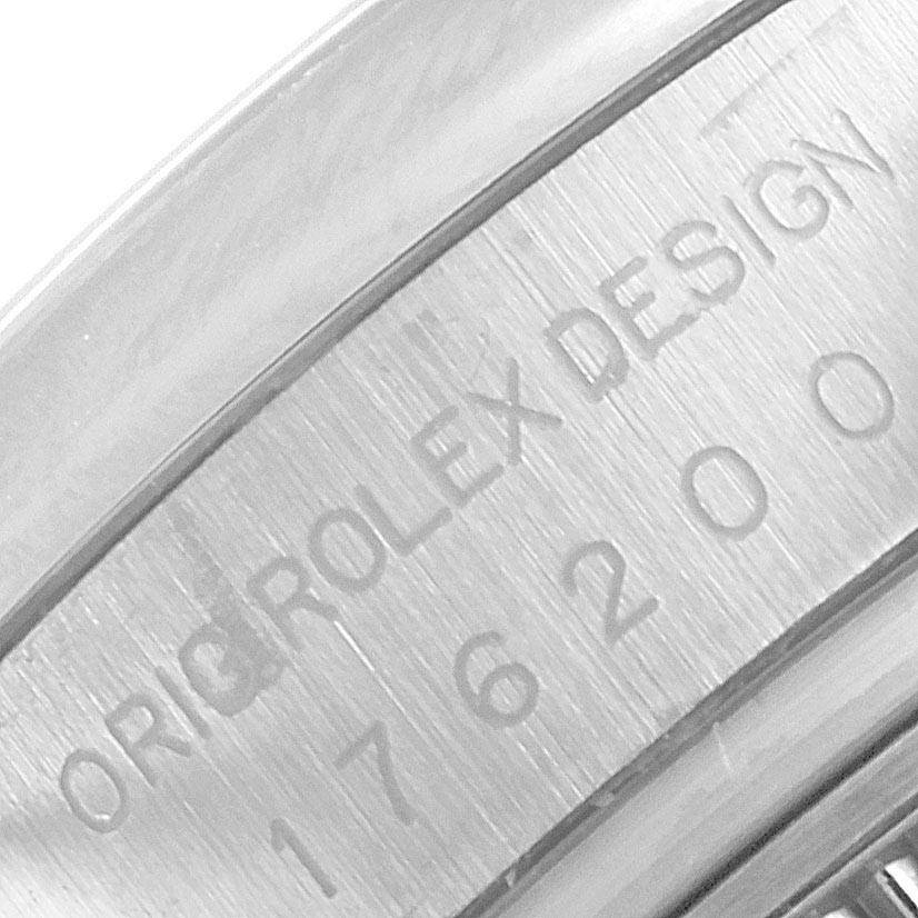 This image shows a macro view of the engraved serial number and "Rolex Design" text on the case of a Rolex Oyster Perpetual 176200 Women's Stainless Steel Green Dial 176200 Women's Stainless Steel Green Dial watch.