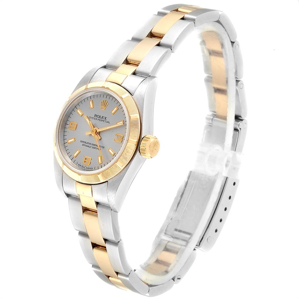 The image shows a side view of a Rolex Oyster Perpetual 67233 Women's Steel and Gold (two tone) Grey Dial 67233 Women's Steel and Gold (two tone) Grey Dial watch, highlighting its two-tone bracelet, crown, and dial.