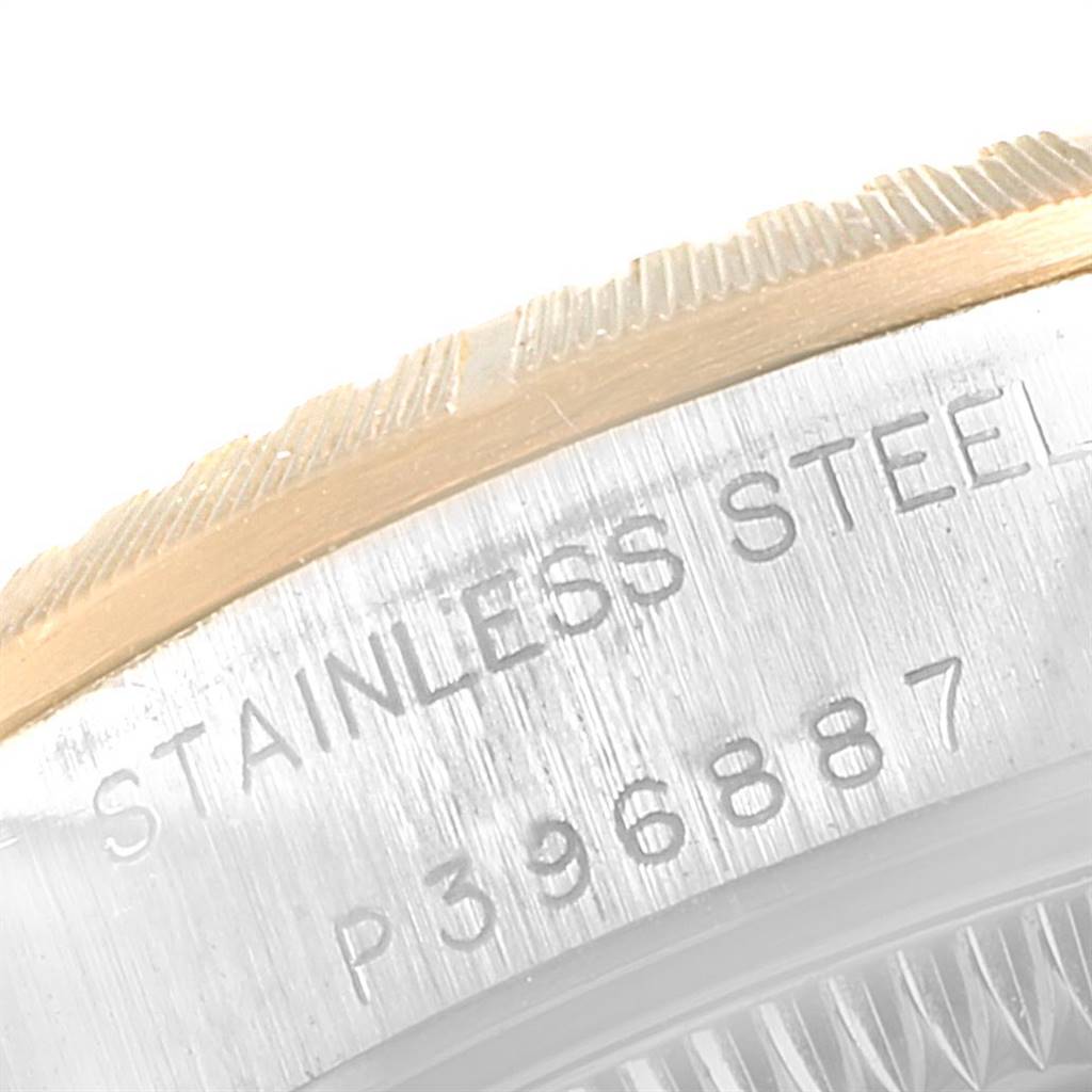 This close-up image of a Rolex Oyster Perpetual 76243 Women
s Steel and Gold (two tone) Black Dial 76243 Women
s Steel and Gold (two tone) Black Dial watch shows the engraved serial number and part of the bezel.