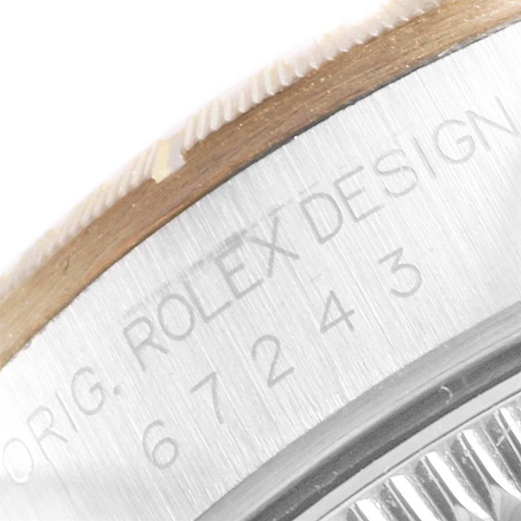 The image shows a close-up of the side of a Rolex Oyster Perpetual 67243 Women
s Steel and Gold (two tone) Champagne Dial 67243 Women
s Steel and Gold (two tone) Champagne Dial watch case, focusing on the bezel and engraved serial numbers.