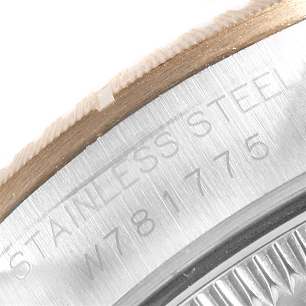 This close-up image of a Rolex Oyster Perpetual 67243 Women
s Steel and Gold (two tone) Champagne Dial 67243 Women
s Steel and Gold (two tone) Champagne Dial watch shows part of the stainless steel case with the watch
s serial number engraved.