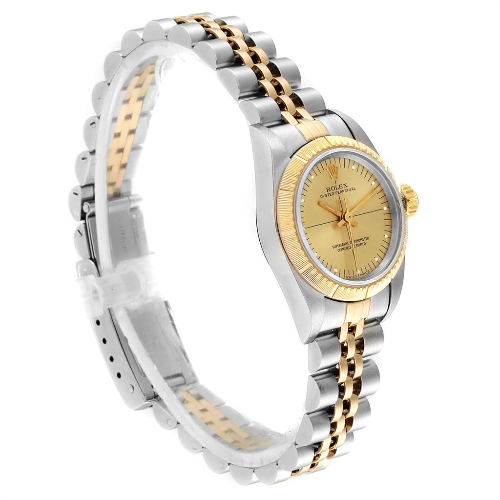 The Rolex Oyster Perpetual 67243 Women
s Steel and Gold (two tone) Champagne Dial 67243 Women
s Steel and Gold (two tone) Champagne Dial watch is shown in a three-quarter view, highlighting its dial, bezel, and two-tone bracelet.