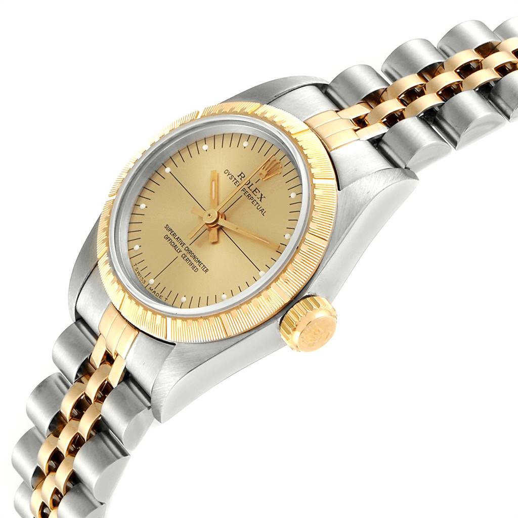 The Rolex Oyster Perpetual 67243 Women
s Steel and Gold (two tone) Champagne Dial 67243 Women
s Steel and Gold (two tone) Champagne Dial watch is shown at a tilted angle, highlighting the gold and silver bracelet, bezel, crown, and dial.