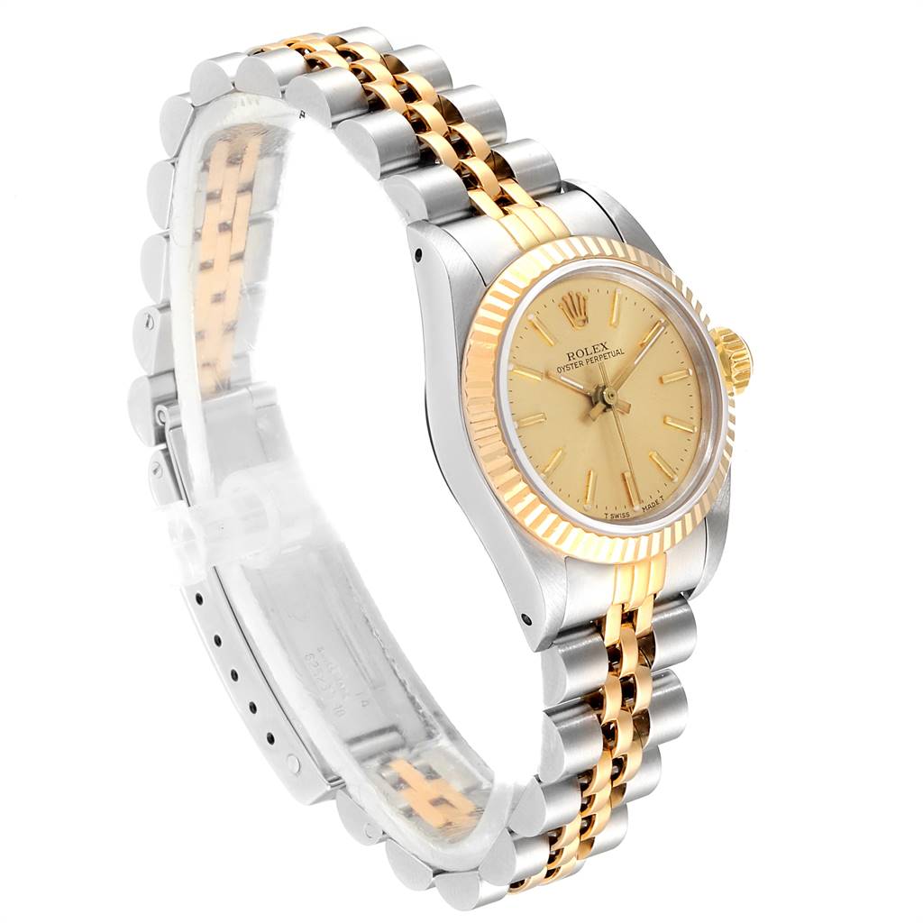 This Rolex Oyster Perpetual 67193 Women
s Steel and Gold (two tone) Champagne Dial 67193 Women
s Steel and Gold (two tone) Champagne Dial watch is shown from a side angle, displaying its two-tone bracelet, dial, bezel, and crown.