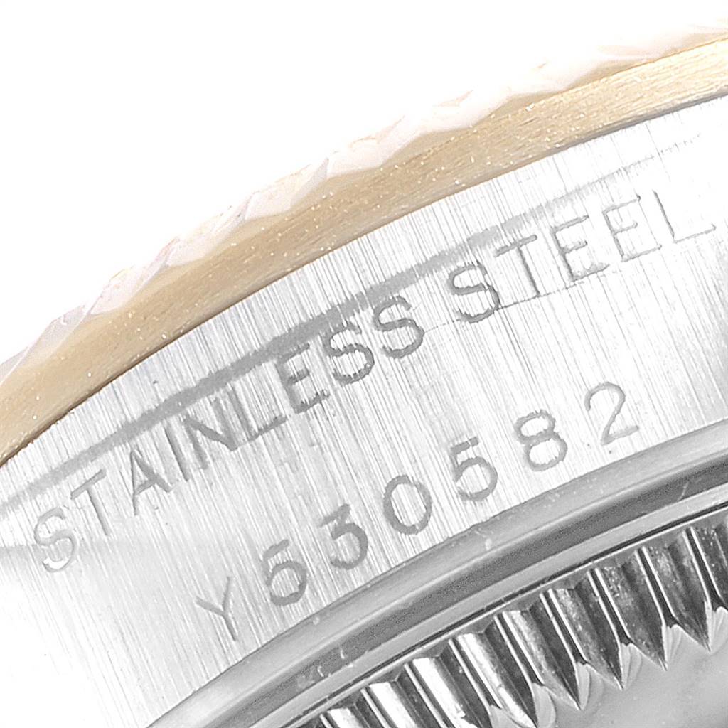 The image shows a close-up of the serial number engraving on the bezel of a Rolex Oyster Perpetual 76193 Women's Steel and Gold (two tone) Black Dial 76193 Women's Steel and Gold (two tone) Black Dial watch.