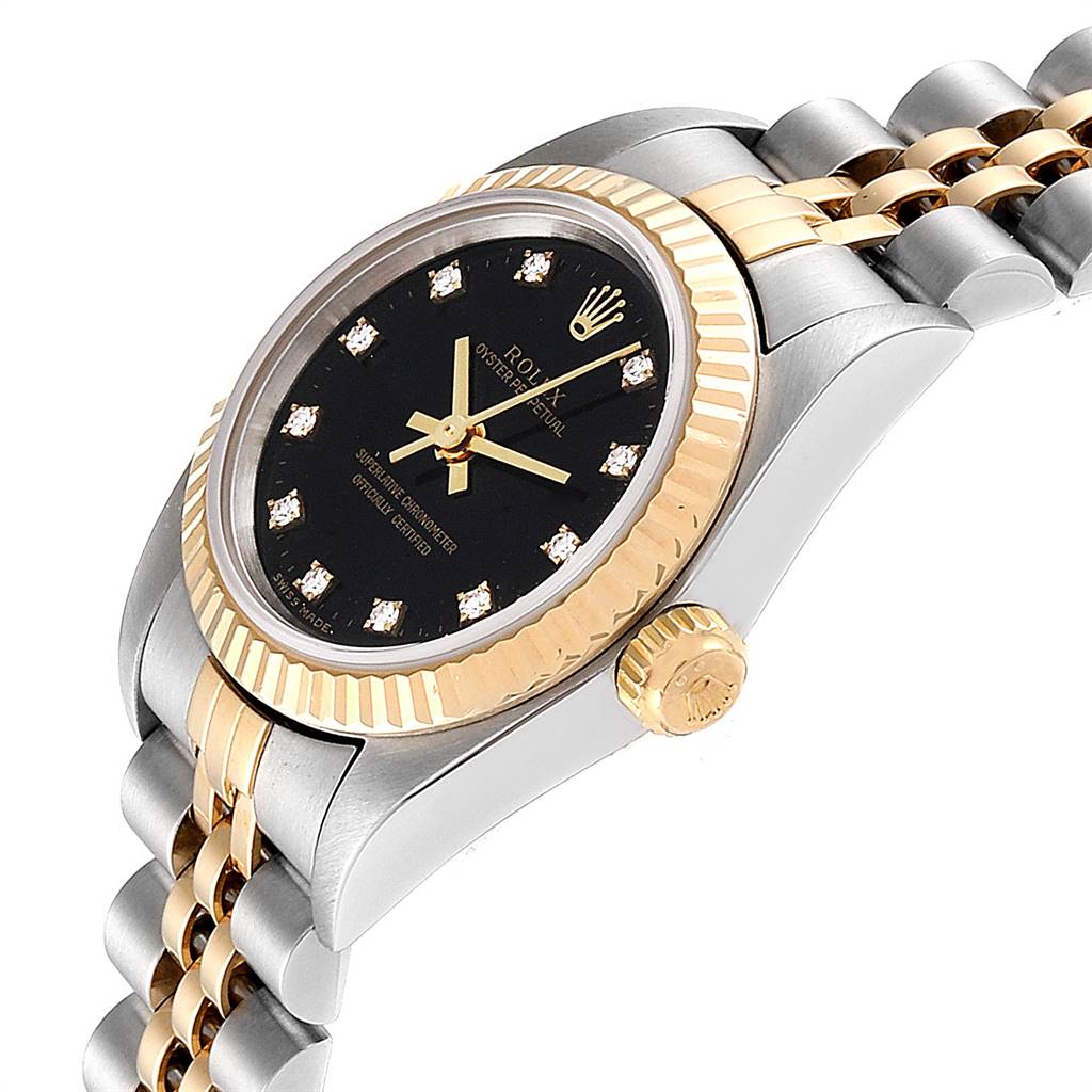 This image shows a Rolex Oyster Perpetual 76193 Women's Steel and Gold (two tone) Black Dial 76193 Women's Steel and Gold (two tone) Black Dial watch at an angle, highlighting its gold bezel, crown, and part of the bracelet.