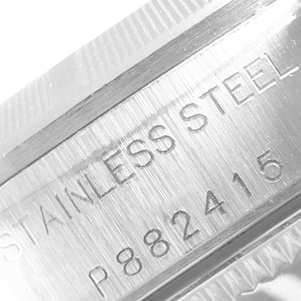 This close-up image shows the stainless steel casing with engravings on a Rolex Oyster Perpetual 76030 Women's Stainless Steel Black Dial 76030 Women's Stainless Steel Black Dial watch.