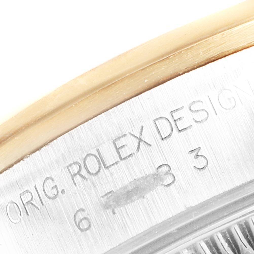This close-up angle shows the inscription "ORIG. ROLEX DESIGN" on the case back of the Rolex Oyster Perpetual 67183 Women
s Steel and Gold (two tone) Champagne Dial 67183 Women
s Steel and Gold (two tone) Champagne Dial watch.