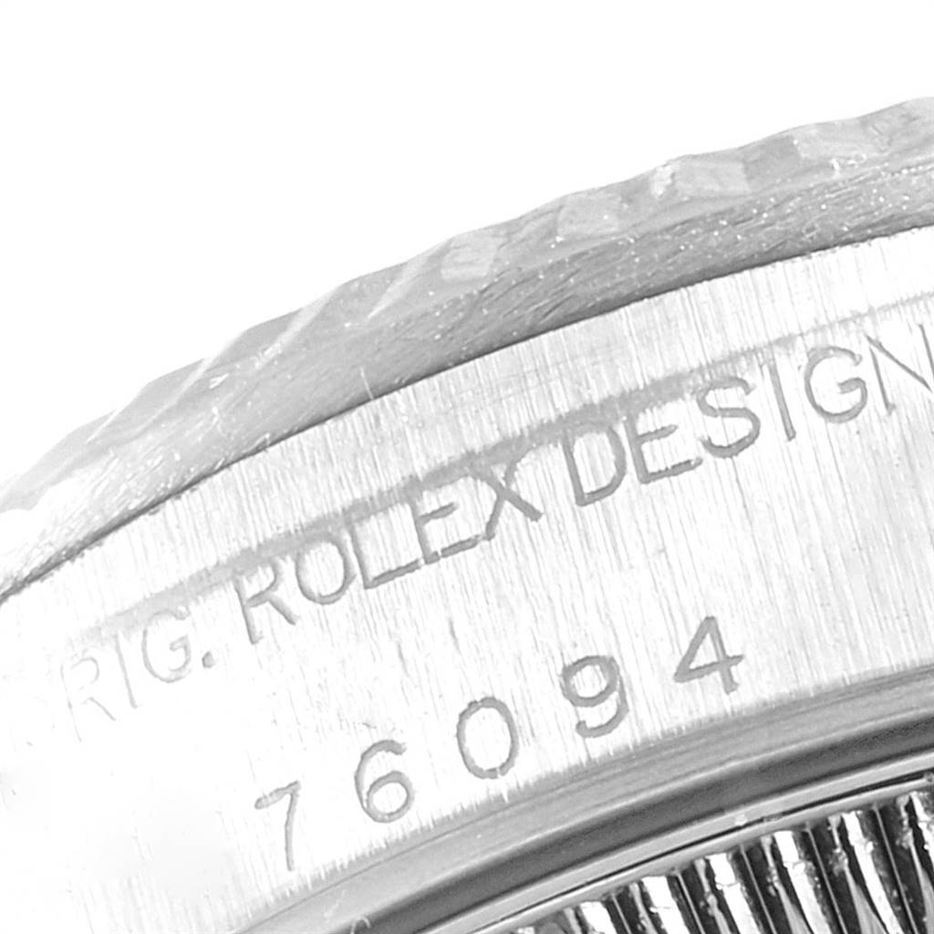 This image shows a close-up of the engraved serial number and "Rolex Design" text on the side of a Rolex Oyster Perpetual 76094 Women's Stainless Steel Silver Dial 76094 Women's Stainless Steel Silver Dial watch.
