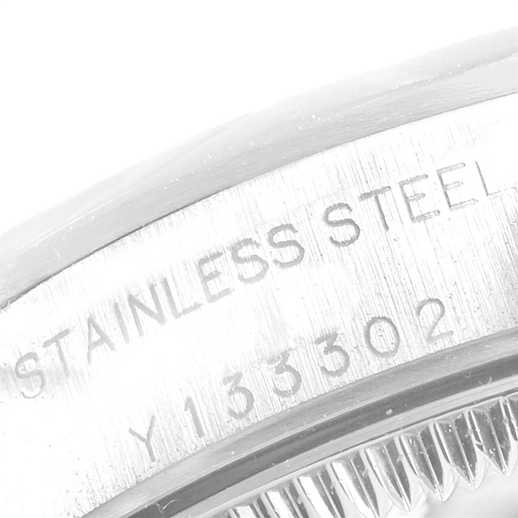 This image shows a close-up of the side case of the Rolex Oyster Perpetual 76080 Women's Stainless Steel Blue Dial 76080 Women's Stainless Steel Blue Dial watch, highlighting the "STAINLESS STEEL" engraving.
