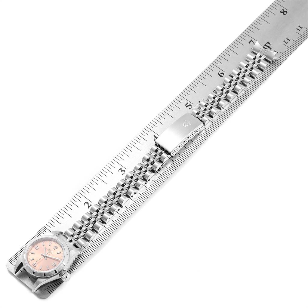 The image shows a side view of a Rolex Oyster Perpetual 76030 Women's Stainless Steel Pink Dial 76030 Women's Stainless Steel Pink Dial watch, focusing on the full metal bracelet and clasp aligned with a ruler.