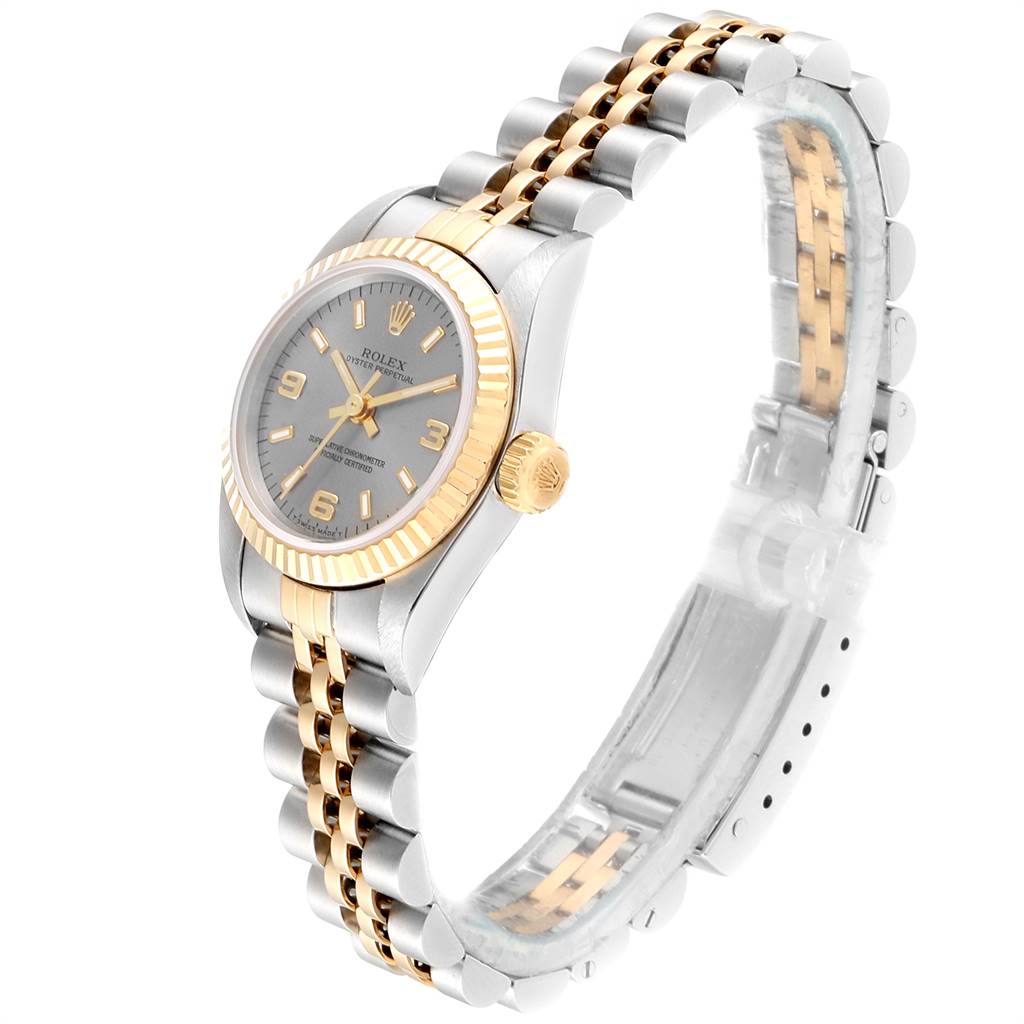 The image shows a side view of a Rolex Oyster Perpetual 67193 Women's Steel and Gold (two tone) Grey Dial 67193 Women's Steel and Gold (two tone) Grey Dial watch with a gold and silver band, bezel, and crown.