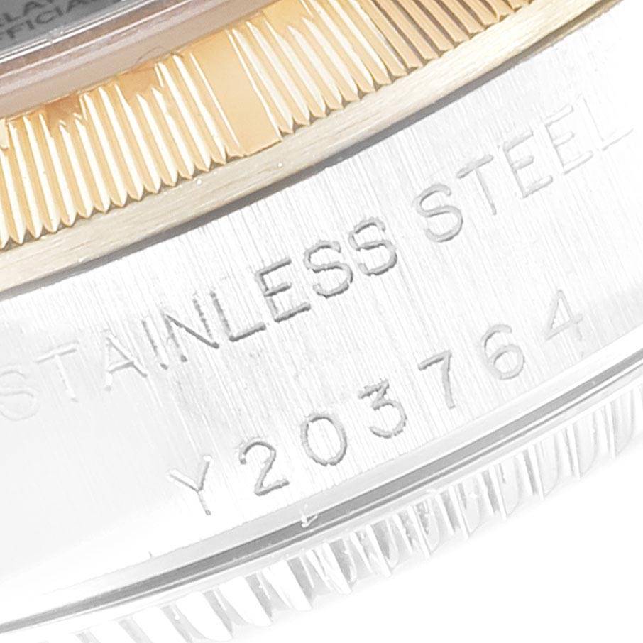 The image shows a close-up of the engraved casing and fluted bezel of a Rolex Oyster Perpetual 76243 Women's Steel and Gold (two tone) Silver Dial 76243 Women's Steel and Gold (two tone) Silver Dial watch.