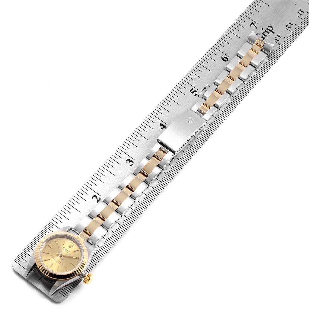 The image shows a Rolex Oyster Perpetual 67193 Women's Stainless Steel Champagne Dial 67193 Women's Stainless Steel Champagne Dial watch laid flat against a ruler, highlighting the watch face, bracelet, and clasp.