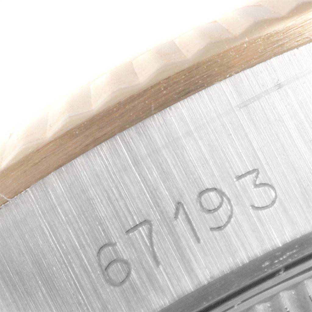This close-up angle of a Rolex Oyster Perpetual 67193 Women
s Steel and Gold (two tone) Champagne Dial 67193 Women
s Steel and Gold (two tone) Champagne Dial watch shows the edge of the bezel and part of the case with engraved numbers.