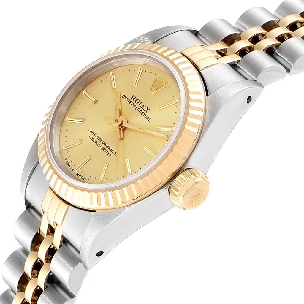 The image shows a side angle of a Rolex Oyster Perpetual 67193 Women
s Steel and Gold (two tone) Champagne Dial 67193 Women
s Steel and Gold (two tone) Champagne Dial, highlighting the gold bezel, crown, and part of the two-tone bracelet.