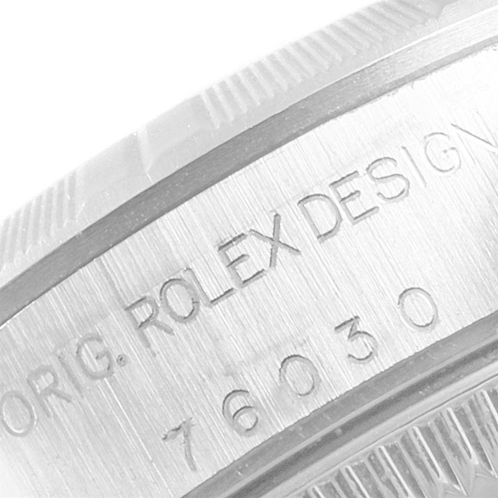 This image shows a close-up view of the case back edge on a Rolex Oyster Perpetual 76030 Women
s Stainless Steel Blue Dial 76030 Women
s Stainless Steel Blue Dial watch, displaying engraved text and numbers.