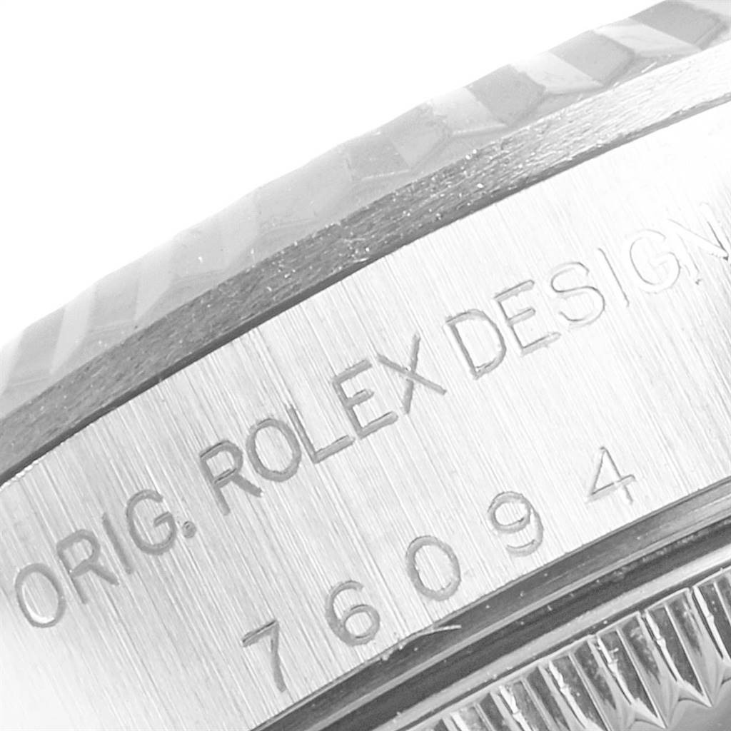 This image shows a close-up of the side of a Rolex Oyster Perpetual 76094 Women's Stainless Steel Silver Dial 76094 Women's Stainless Steel Silver Dial watch, highlighting the engraved "ORIG. ROLEX DESIGN" and model number.