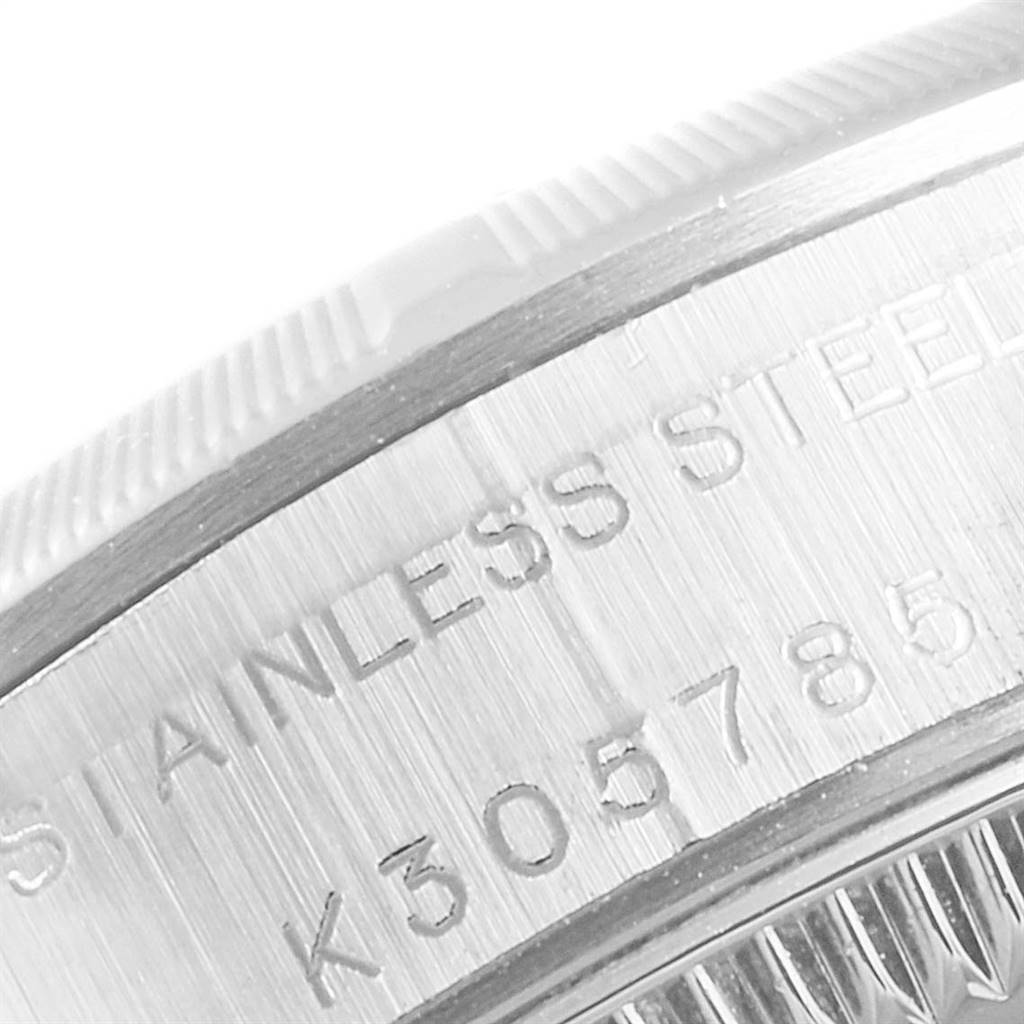 Close-up of the side of a Rolex Oyster Perpetual 76030 Women's Stainless Steel Pink Dial 76030 Women's Stainless Steel Pink Dial watch, showing part of the bezel and engraved stainless steel case back with serial number.