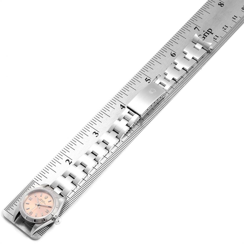 The image shows a Rolex Oyster Perpetual 76030 Women's Stainless Steel Pink Dial 76030 Women's Stainless Steel Pink Dial watch laid flat next to a ruler, displaying its dial and metal bracelet.