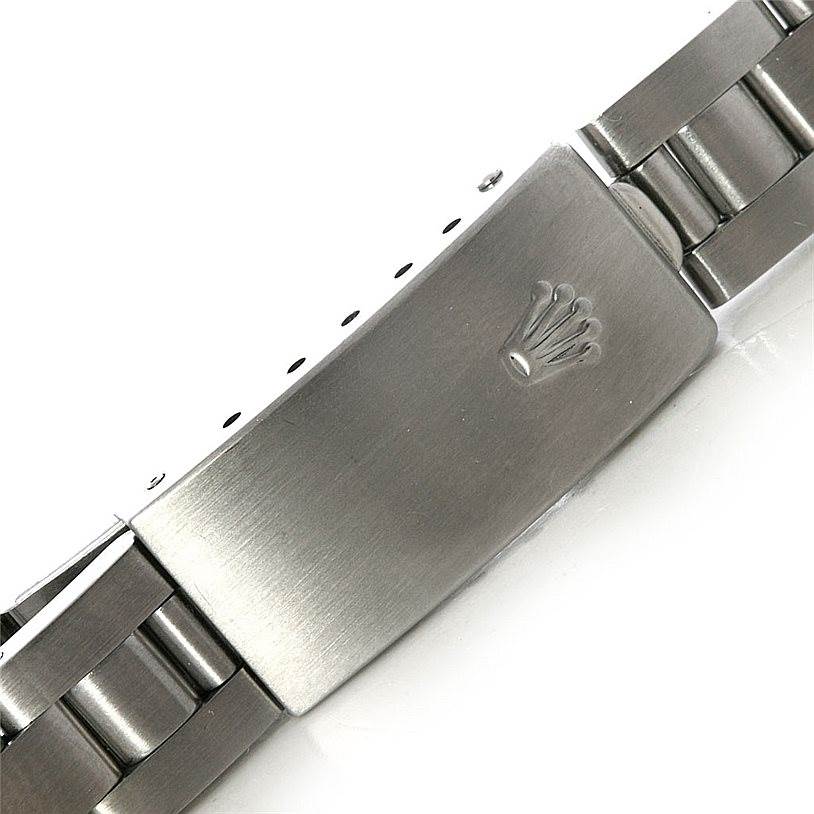 This image shows a close-up of the clasp and part of the stainless steel bracelet of a Rolex Oyster Perpetual 67180 Women's Stainless Steel White Dial 67180 Women's Stainless Steel White Dial watch.