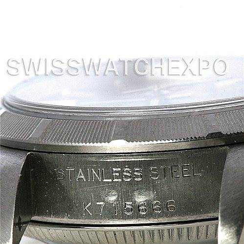 This image shows a close-up of the case and bezel of a Rolex Oyster Perpetual 67180 Women's Stainless Steel Blue Dial 67180 Women's Stainless Steel Blue Dial watch, highlighting the "Stainless Steel" engraving and serial number.