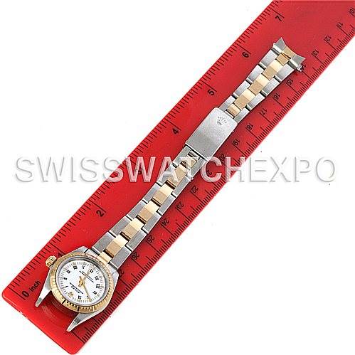 This image shows a Rolex Oyster Perpetual 76243 Women's Steel and Gold (two tone) White Dial 76243 Women's Steel and Gold (two tone) White Dial watch, including the full face and bracelet, laid flat against a red ruler.