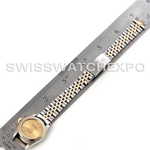 The Rolex Oyster Perpetual 67193 Women's Steel and Gold (two tone) Champagne Dial 67193 Women's Steel and Gold (two tone) Champagne Dial watch is shown in a top-down view, displaying the full bracelet and the face of the watch alongside a ruler.