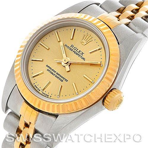 The image shows a close-up, angled view of a Rolex Oyster Perpetual 67193 Women's Steel and Gold (two tone) Champagne Dial 67193 Women's Steel and Gold (two tone) Champagne Dial watch, highlighting the gold face, bezel, crown, and two-tone bracelet.