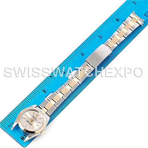 The image shows a Rolex Oyster Perpetual 76183 Women's Steel and Gold (two tone) Silver Dial 76183 Women's Steel and Gold (two tone) Silver Dial watch laid flat on a blue ruler, displaying its face, band, and clasp from a top-down angle.