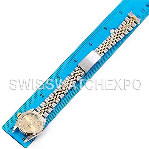 This Rolex Oyster Perpetual 76193 Women's Steel and Gold (two tone) Champagne Dial 76193 Women's Steel and Gold (two tone) Champagne Dial watch is shown from a top-down angle with a focus on the watch face and bracelet, measured against a blue ruler.