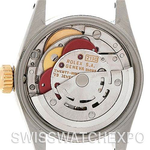 The image shows the inner mechanics of a Rolex Oyster Perpetual 67193 Women
s Steel and Gold (two tone) Silver Dial 67193 Women
s Steel and Gold (two tone) Silver Dial watch, including gears and the movement mechanism from the back.